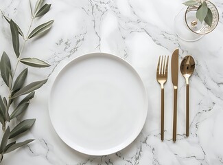 photo of a simple flat lay table setting with golden cutlery, a white plate 