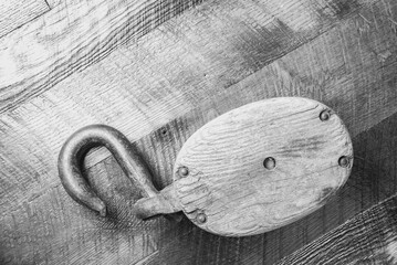 Antique block and tackle, wooden background, black and white.
