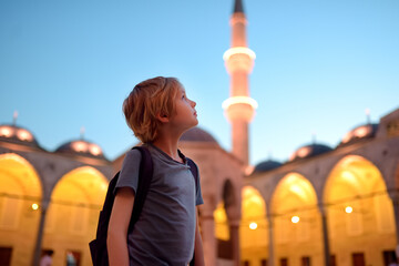Preteen boy visiting The Blue Mosque -Sultan Ahmed Mosque. Tourist attraction of Istanbul city, Turkey