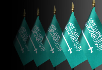 Row of Saudi Arabian flags on a dark background in perspective