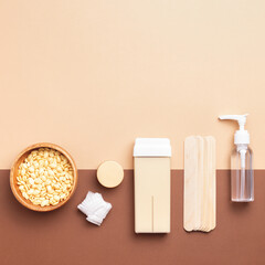 Square composition with cosmetology depilation, epilation tools on beige-brown background. Hair removal, body care, beauty treatment concept, copy space.
