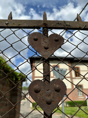 Rusty heart shaped ornaments of a chainlink fence