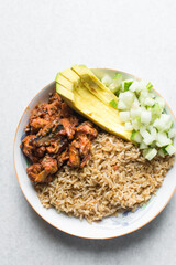 Overhead view of rice mackerel bowl, top view of healthy rice bowl, basmati rice mackerel avocado and cucumbers in a white bowl