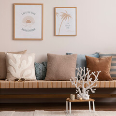 Sunny and bright space of living room with stylish sofa, pillows, coffee table, mock up poster...