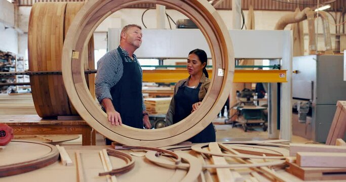Workshop, carpenter and collaboration with woman, wood and working on frame in startup. Business, entrepreneur and mature man with intern in garage, professional and manufacturing for project