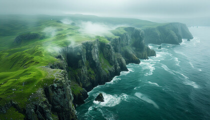 A beautiful view of a rocky coastline with a foggy mist in the air - obrazy, fototapety, plakaty