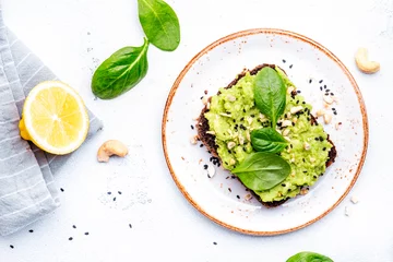 Stoff pro Meter Avocado toasts with spinach and cashew nuts sprinkled with sesame seeds on white table background, top view © 5ph