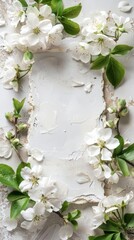 Delicate white apple blossoms frame a textured white paper, their green leaves contrasting softly against a white textured background.