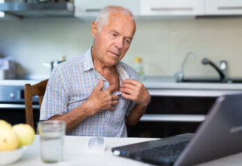 Elderly man talks on a video call, consulting using a laptop