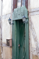 close-up Detail Aufnahme von einer Haust&uuml;r mit kleinen Laternen links und rechts in gr&uuml;n mit wundersch&ouml;nen Schnitzereien in einem Fachwerkhaus