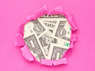 money US dollars in the hole of pink paper - 779790343