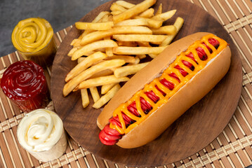 hot dog with large sausages different varieties with dressings mustard mayonnaise ketchup onion bacon cheese cucumbers and French fries