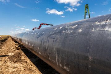 Gas and oil pipeline construction. Pipes welded together. Big pipeline is under construction. Cloudy sky - 779805584