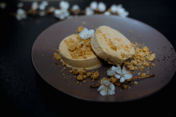Chocolate ice cream scoop in white bowl with mint leaves on sand color stone background. Summer food concept with copy space.