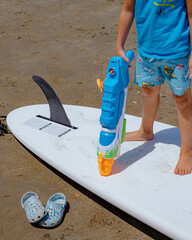 a kid on a surfboard holding a water dispenser.
