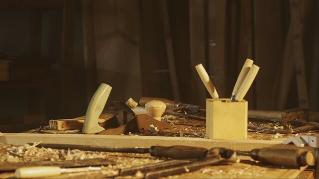Cinematic shot of table with tools in the garage. Professional carpenter tools, equipment and wooden materials laying on the table in workshop.