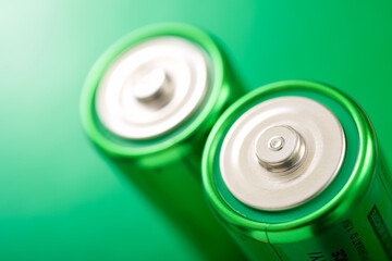 Two green batteries on a green table