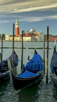 Gimbal shot of gondolas at San Giorgio Maggiore in Venice. Swinging boat on the shore in Venice, Italy. Vertical Screen