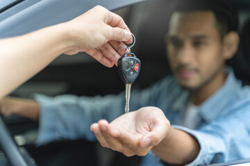 Buy second-hand auto or rent a car concept, Close-up hand of used car agent giving an auto key to...
