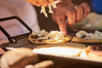 Mujer latina preparando sopes de quesillo con frijol. comida oaxaqueña - obrazy, fototapety, plakaty
