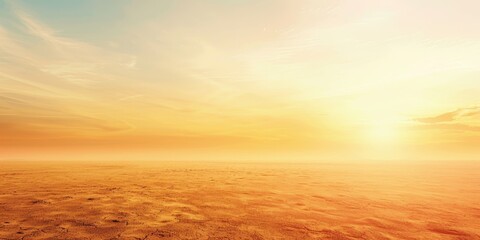 A large, empty field with a bright orange sun in the sky. The sky is mostly clear, with only a few clouds scattered throughout. The sun is positioned low in the sky - obrazy, fototapety, plakaty