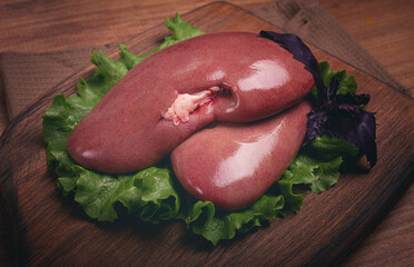 raw pork kidneys, on a chopping board, close-up, top view, no people,
