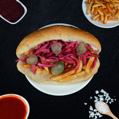 Loaded Sausage Sandwich with Fries and Pickles
