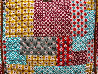 A colorful quilt with a variety of patterns and colors