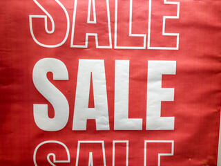 A red sign with white letters that say "SALE" on it