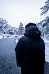 Fototapeta na wymiar Back view, youthful explorer embraces snowy Sierra de Guadarrama scenery in rural Spain.