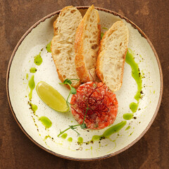 salmon tattar with green oil and lime flat lay