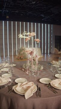Wedding flower arrangement on the table in pink and beige colours. Floristic compositions of roses on party banquet dining table. Vertical video.	