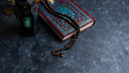 Quran with tasbih and lantern isolated on grey colour background