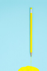 Pencils and yellow paint on blue backgrounc. Creative concept.