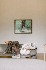 woman with newspaper over face in modern living room