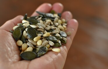 peeled pumpkin sunflower seeds and pine nuts in the palm