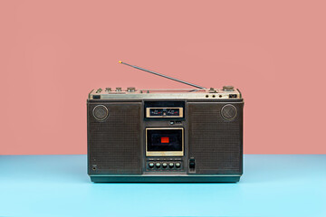 Front view, Retro outdated portable stereo boombox radio cassette recorder on colorful background,...