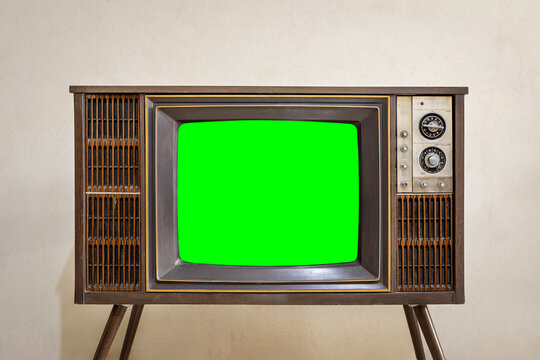 Retro old TV with chroma key green screen standing in the room at home. vintage television with legs, front view