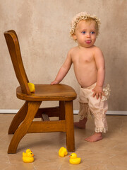 Blonde baby first steps holding chair - 779848963