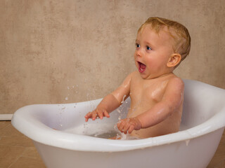 Blonde baby boy splashing