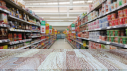 Wooden table top (counter bar) with blur supermarket grocery store background. Banner for advertise...
