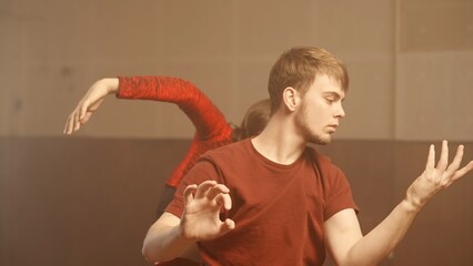 Professional dancers performing dance show. Young man and woman contemporary dancers perform modern...