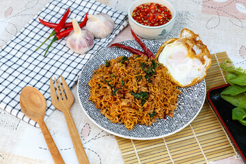 Spicy stir fried noodle with seafood and basil leaves with egg