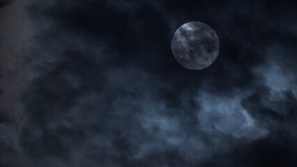 The moon peeks through clouds, casting an eerie blue glow in the night sky.