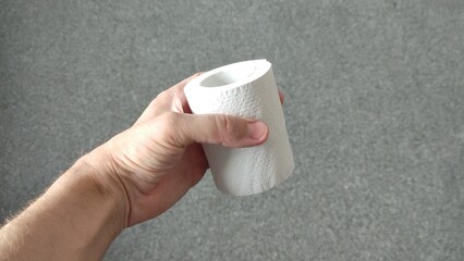 Man holding a roll of toilet paper in left hand
