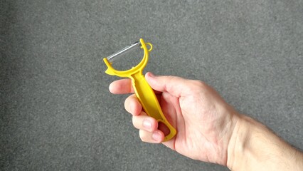 Man holding vegetable peeler in right hand