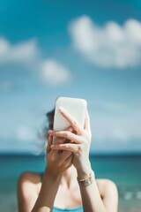 Woman with mobile phone on the beach.