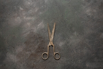Vintage metal tailor's scissors on a colored dark grunge background. Top view, flat lay.