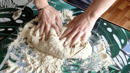 Woman kneading dough on the table