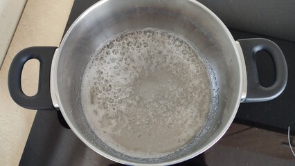 Boiling sugar in a pan on the stove. Making homemade paste for sugaring.